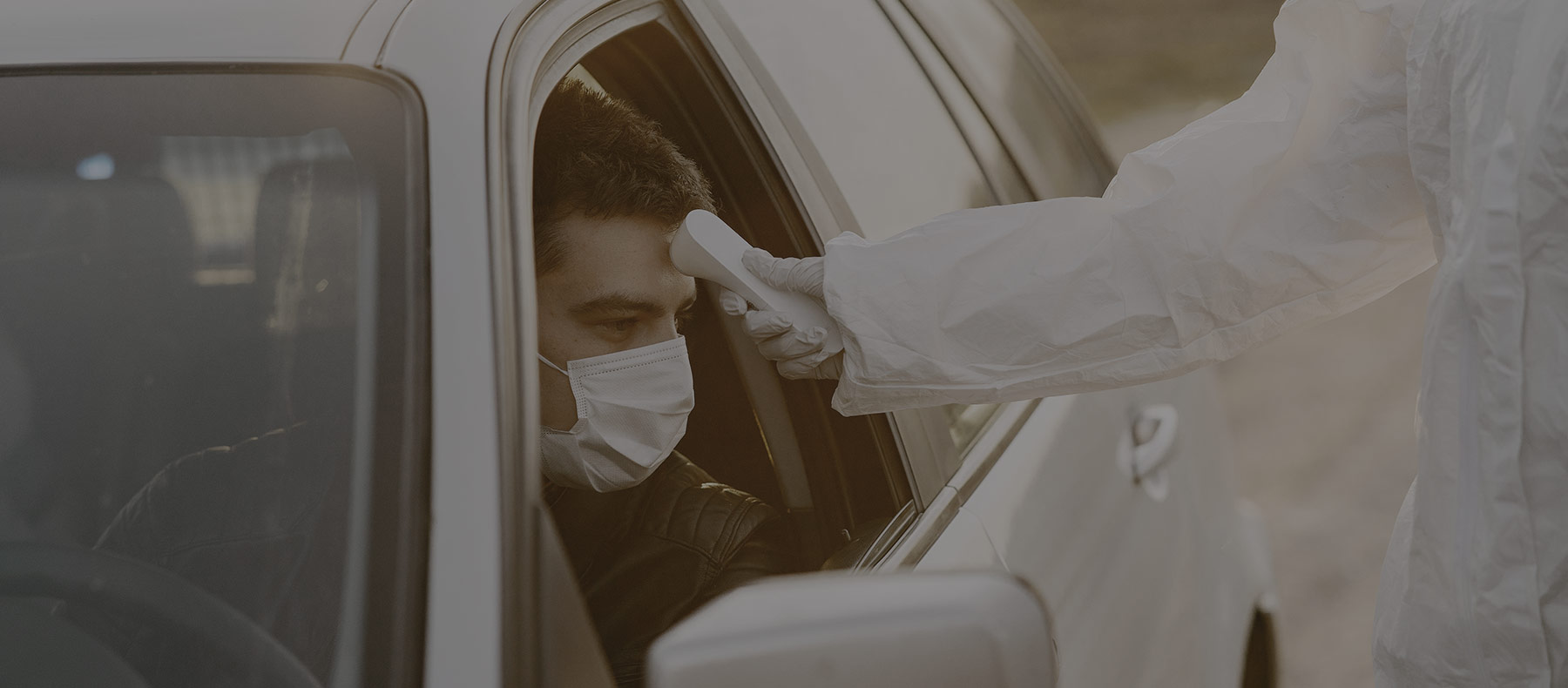 Man getting his temperature checked in his vehicle