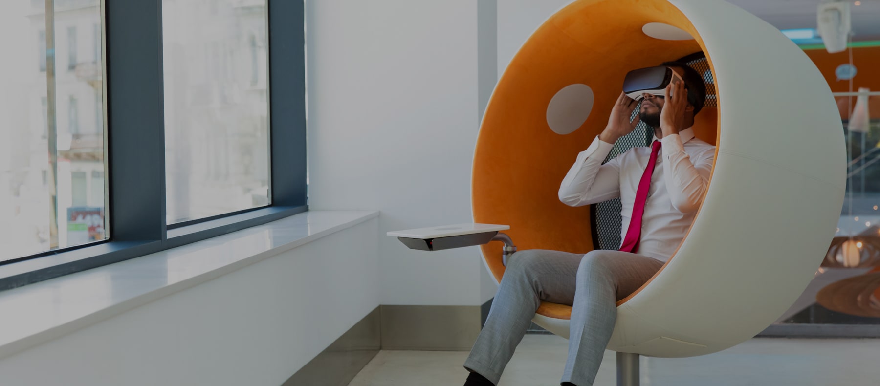 Man sitting in bubble chair wearing VR gear