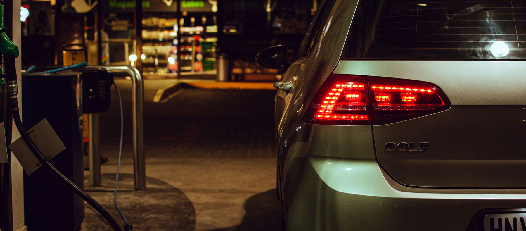 Car headlights lit up neon at petrol station