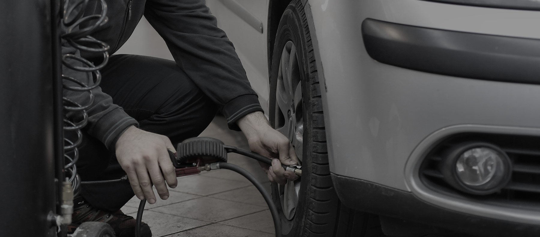 Person filling up tire air at a petrol station